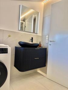 une salle de bains avec un lavabo et un miroir dans l'établissement Haus Rautenweg, à Dornbirn 35 autres photos