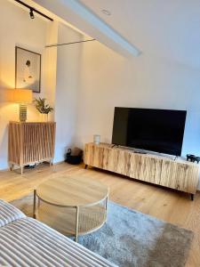 un salon avec une grande télévision à écran plat dans l'établissement Haus Rautenweg, à Dornbirn