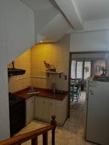 a kitchen with a sink and a stove and a refrigerator at Departamento Mi Casa in La Porteña