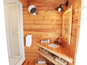 ein Badezimmer in einer Blockhütte mit Waschbecken und Spiegel in der Unterkunft Beverly Glamping - Vacation STAY 89349v in Kakegawa + 48 Fotos