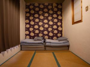 een kamer met twee slaapzakken aan de muur bij Himeji 588 Guest House in Himeji