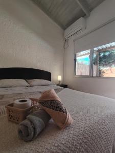 una camera da letto con un letto con asciugamani sopra di Chula - Posada a Punta del Este Altre 5 foto
