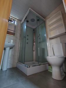 un bagno con doccia in vetro e WC di Chula - Posada a Punta del Este