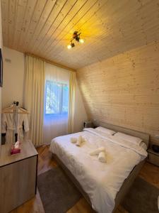 a bedroom with a bed with two towels on it at Catunu lupului village Cabana Monte Benito in Cotorăşti +77 photos