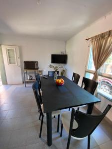 a dining room with a black table and chairs at Alma del Pinal in Garupá