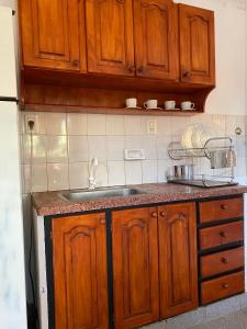 una cucina con mobili in legno e un lavello di Alma del Pinal a Garupá