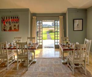 a dining room with a table and chairs and an open door at Soames Hotel & Jack' s Bar in Nanyuki