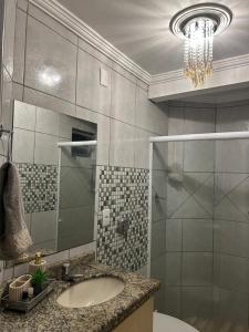 a bathroom with a sink and a glass shower at Recanto familiar in Florianópolis +26 photos