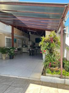 a patio with awning and tables and flowers and plants at Recanto familiar in Florianópolis