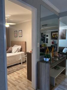 a room with a bedroom with a bed and a mirror at Recanto familiar in Florianópolis
