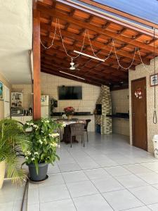 a patio with a table and a tv on a ceiling at Recanto familiar in Florianópolis