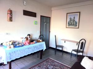 Zimmer mit einem Tisch, einem Tisch und Stühlen in der Unterkunft Pousada Santana in Ouro Preto