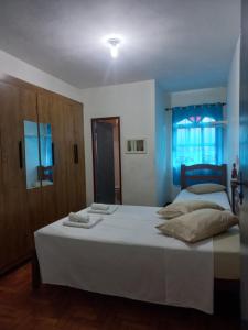 ein Schlafzimmer mit einem großen Bett mit weißen Laken und Kissen in der Unterkunft Pousada Santana in Ouro Preto