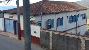 ein Gebäude mit blauen Fensterläden und einem Zaun in der Unterkunft Pousada Santana in Ouro Preto