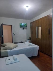 ein Hotelzimmer mit zwei Betten und einem Schrank in der Unterkunft Pousada Santana in Ouro Preto