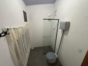 a bathroom with a shower curtain and a toilet at Chalé a Beira em Arroio do Sal in Arroio do Sal