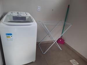 eine Waschmaschine in einem Zimmer mit Besen in der Unterkunft Casa Finger 800m do Centro e do Núcleo de casas Enxaimel anfitriões residem ao lado in Ivoti