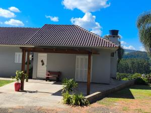 ein kleines weißes Haus mit einem Dach in der Unterkunft Casa Finger 800m do Centro e do Núcleo de casas Enxaimel anfitriões residem ao lado in Ivoti