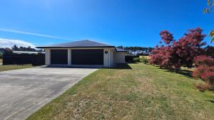 a house with a garage in a yard at 10 @ Wai Matangi in Turangi +42 photos