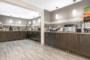 a kitchen with wooden cabinets and a counter top at Super 8 by Wyndham Rochester Mayo Clinic Area in Rochester