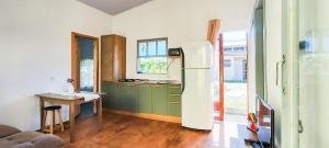 a kitchen with a refrigerator and a table in it at Chalé a Beira em Arroio do Sal in Arroio do Sal