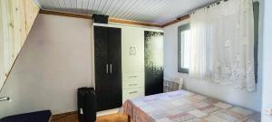a bedroom with a bed and a dresser and a window at Chalé a Beira em Arroio do Sal in Arroio do Sal