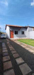 a white house with a car parked in front of it at Casa, Perto de Praias, Shoppings e Valparaíso in Maioba