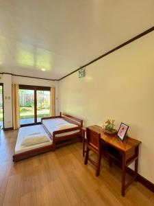 una stanza con un letto e un tavolo di Surf House Palawan a San Vicente