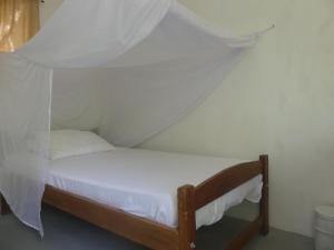 een klein bed met een baldakijn in een kamer bij Dogsheltercafepalomino in Palomino