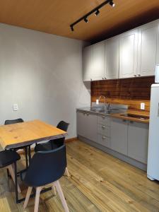 een keuken met witte kasten en een houten tafel en stoelen bij Cabana Penélope in Alfredo Wagner +4 foto's