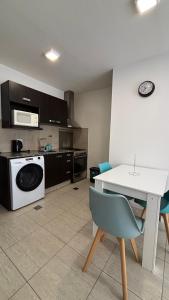eine Küche mit einer Waschmaschine und einem weißen Tisch in der Unterkunft Costanera Sur Departamento in Río Gallegos + 2 Fotos