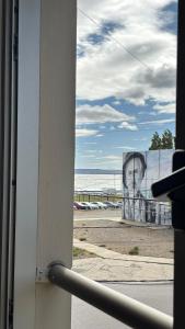 ein Blick auf das Meer aus einem Fenster eines Gebäudes in der Unterkunft Costanera Sur Departamento in Río Gallegos