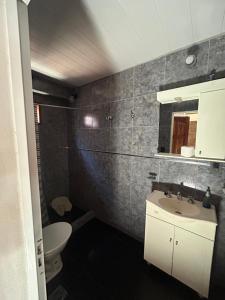 a bathroom with a white sink and a toilet at Departamento cómodo in Concepción del Uruguay