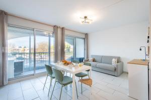 ein Wohnzimmer mit Tisch, Stühlen und Sofa in der Unterkunft Large Studio Waterfront Air-conditioned Beach 1 min away in La Celle-sous-Gouzon