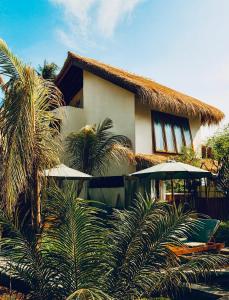 ein Haus mit Palmen davor in der Unterkunft Corabelle Gili Air - Adults Only Boutique Retreat in Gili Air