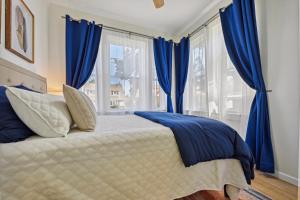 een slaapkamer met blauwe gordijnen en een bed bij The Hamilton Elm in Teaneck