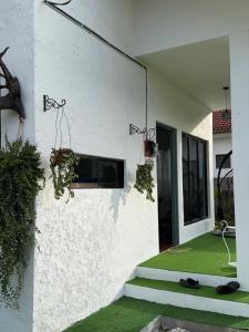 a white house with some plants on the side of it at Science and Astronomy Garden in Kampung Dengkil +3 photos