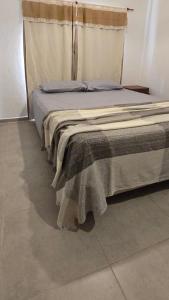 un letto con una coperta in una stanza di Arcoiris Dptos a Paso de la Patria