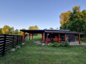 een klein schuurtje met een hek in een veld bij Acojedora Cabaña en el Sur Panguipulli 