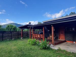 een houten huis met een veranda en een hek bij Acojedora Cabaña en el Sur Panguipulli  +13 foto's