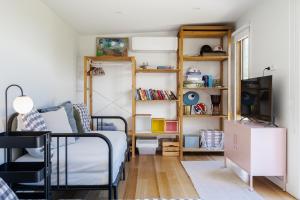 een slaapkamer met een bed en een boekenplank bij The Hillside Project in Frankston South
