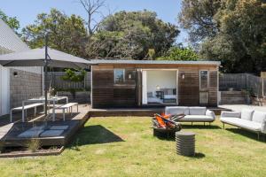 een achtertuin met een bank en een paraplu bij The Hillside Project in Frankston South