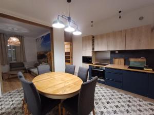 eine Küche und ein Esszimmer mit einem Holztisch und Stühlen in der Unterkunft Villa Maris Stella à 250m de la plage de Petit Fort Philippe in Gravelines