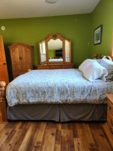 een slaapkamer met een groot bed en een spiegel bij 1st Chair Mountain Resort in Nelson