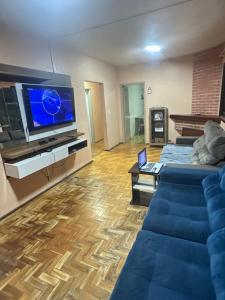 a living room with a couch and a flat screen tv at pousada cardoso - casa 2 in São Gabriel