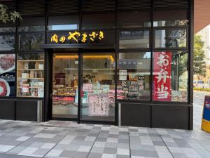 einen Laden vor einem Laden mit Schildern darauf in der Unterkunft 3 min JR Direct to Skytree Asakusa Shinjuku Sea Heim in Tokio