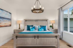 een slaapkamer met een groot bed met blauwe kussens bij Marbella Lane Wave HS w EV Charger Oceanfront in San de Fuca