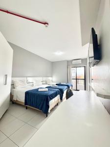 una camera da letto con due letti e una TV a parete di Hotel Beach Canasvieiras a Florianópolis