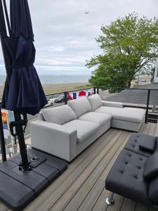 un canapé blanc assis sur une terrasse avec un parasol dans l'établissement Ocean Spray Inn, à Winthrop