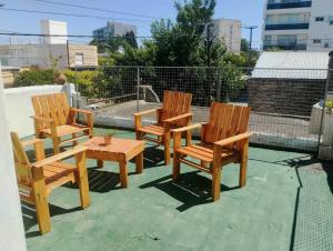 three wooden chairs and a table on a patio at Vm casa in Villa María